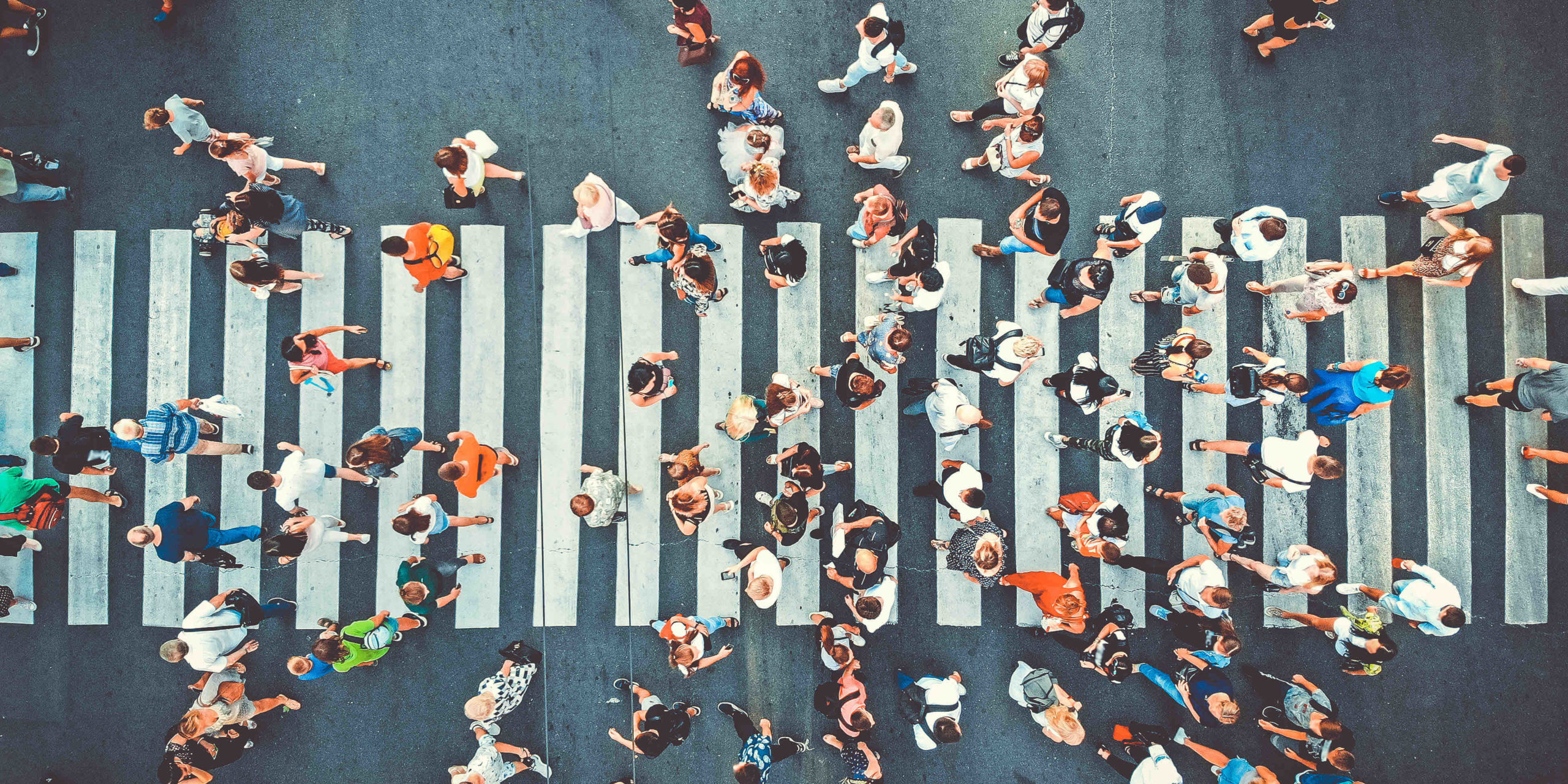 Aerial. People crowd on pedestrian crosswalk. Top view background. Toned image.